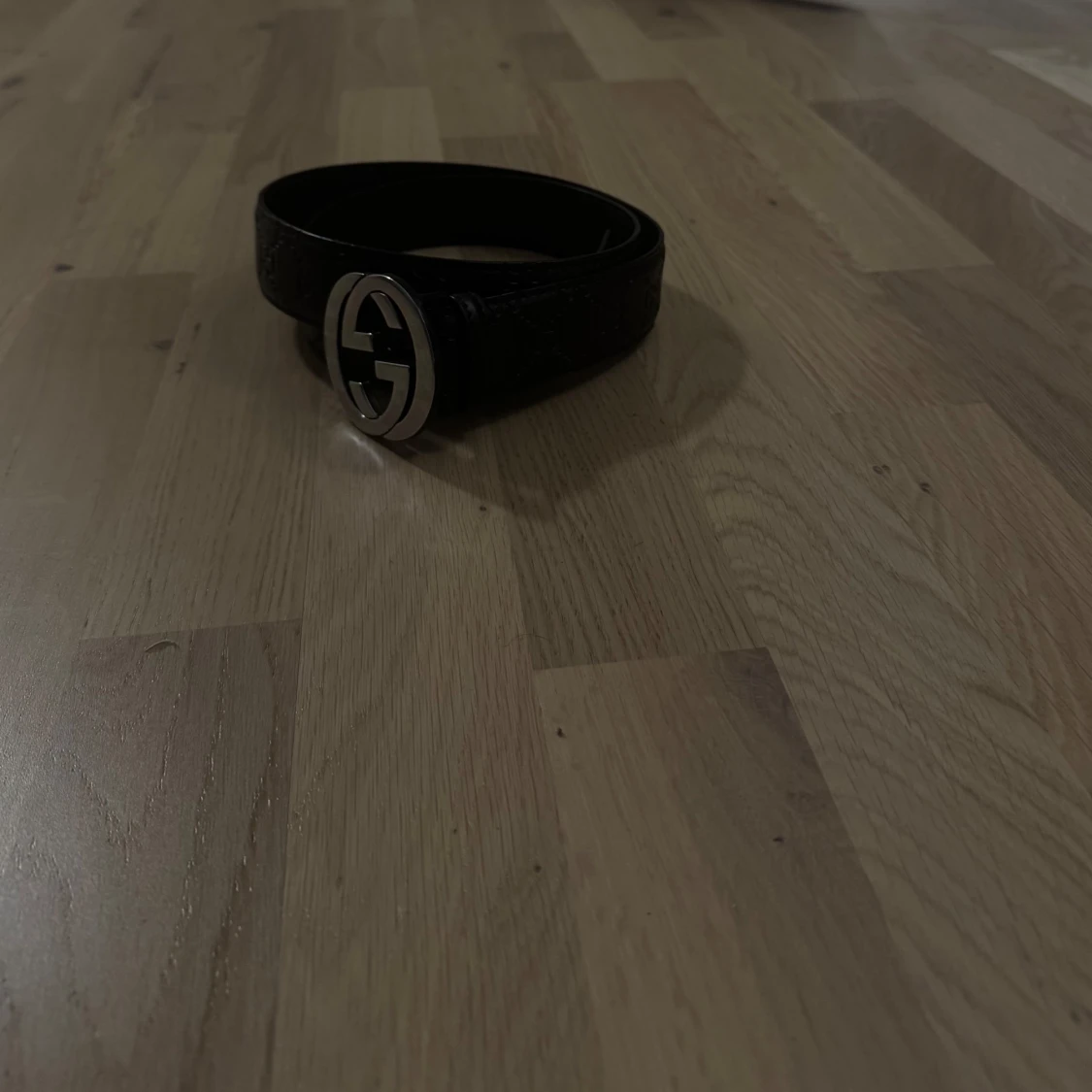 Svart bälte med silverfärgat spänne