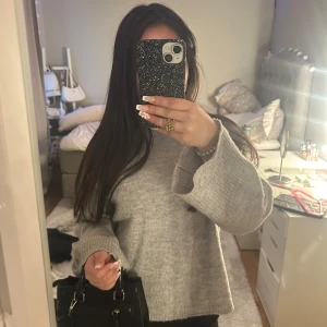 Grå stickad tröja - Säljer en mysig grå stickad tröja med långa ärmar och en avslappnad passform. Perfekt för kyliga dagar och enkel att matcha med olika outfits. Tröjan har en klassisk design som aldrig går ur stil. Bra skick, pris kan diskuteras.