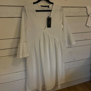 Vit klänning från Vero Moda - Säljer en söt vit klänning från Vero Moda med v-ringning och trekvartsärmar. Klänningen har ett fint broderat mönster och volangdetaljer vid ärmsluten. Perfekt för sommarens alla tillfällen! Den har inte kommit till användning så hoppas någon annan känner sig fin i den 🌸