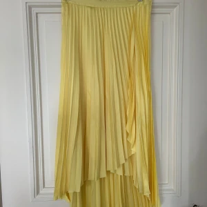 Gul plisserad kjol från & Other Stories - Säljer en solgul plisserad midikjol kjol från & Other Stories. Den är endast använd ett fåtal gånger och är i fint skick! Jag är 178 cm och på mig går den ner till vaden.