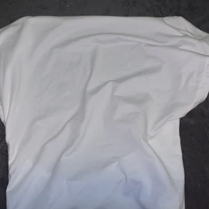 Vit croppad t-shirt från SHEIN MOD - Snygg vit croppad t-shirt från SHEIN MOD. Perfekt för en avslappnad stil med korta ärmar och en tight passform. Enkel och stilren design som passar till det mesta.