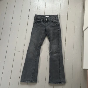 Grå bootcut jeans - Snygga grå bootcut jeans med låg midja och klassisk femficksdesign. Jeansen har dubbla knappar och dragkedja framtill. Perfekta för en avslappnad stil.❤️💯
