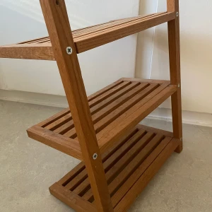 Trähylla i fint skick - Säljer en stilren och praktisk trähylla med tre hyllplan. Perfekt för förvaring i hallen, badrummet eller köket. Stabil konstruktion och i fint skick. Pris kan diskuteras      Höjden: cirka 51 cm Bredden: cirka 38,5 cm