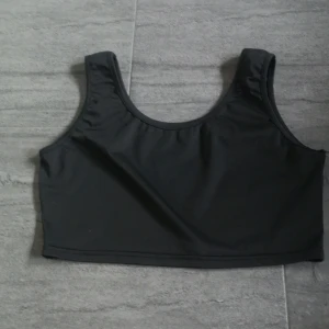 Svart linnetopp - Snygg svart linnetopp med breda axelband och rund halsringning. Perfekt för en stilren look och enkel att matcha med olika outfit eller att sova i, mjukt skönt material men lite sönder vid sidan, går att sy lätt men vi sänker därför priset billigt. 