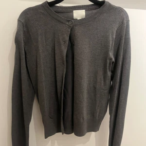 Grå kofta med knappar från Hm🤍 - Säljer en basic kofta från hm, aldrig använd och därför säljs den🤍 passar perfekt till vardag!!!