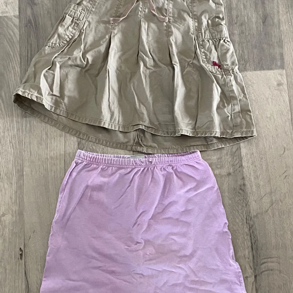 Superfint paket i stl 110/116! Helt och rent klädpaket men i använt skick. Innehåll: En lila kjol. Ett par jeansshorts. Ett par mjuka, sköna blå byxor med spiderman tryck. Mjuka, gosiga vinröda fleecebyxor. Trekvart byxor med blommor. Rosa/vitrandiga trekvart byxor. Vita strumpbyxor. Mörkgrön, gosig hoodie med dragkedja i materialet velour. Grönt linne. Orange T-shirt med tryck. Beige kjol. . Farkut & Housut.