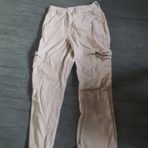 Beige cargobyxor från Shein - Snygga beige cargobyxor från Shein i storlek Petite XS. Byxorna har flera praktiska fickor och en knappdetalj i midjan. Perfekta för en avslappnad stil.