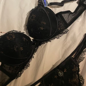 Underklädsset från New Yorker - Säljer ett jättefint  helt oanvänt underklädsset från New Yorker! Ett svart set med jättefina guldiga detaljer, den guldiga ”kedjan” som syns på bild 3 går att koppla bort💗 Trosorna är i storlek S och bh:n är i storlek 75B. Lapparna är kvar så de är fortfarande helt nya, nypris ca 250 för båda💞
