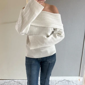 Vit ribbad offshoulder tröja från Nelly - Säljer en stilren vit ribbad tröja från Nelly med offshoulder-design. Tröjan har långa ärmar. Köpt på nelly 