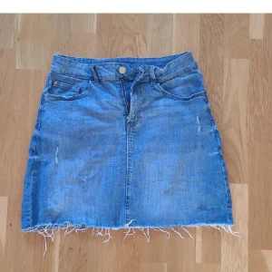 Jeanskjol från Lindex - Säljer en jeanskjol från Lindex, storlek 170, i en klassisk blå färg. Den har fickor både fram och bak. Köparen står för frakten 