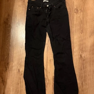 Svarta bootcut jeans - Snygga svarta bootcut jeans med klassisk femficksdesign och knappgylf. Perfekta för en stilren look och passar till många olika outfits.