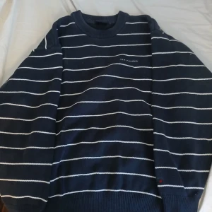 Mörkblå randig tröja från Red/Green - Säljer en snygg mörkblå tröja från Red/Green med vita ränder. Tröjan har långa ärmar och en rund halsringning. Perfekt för en stilren look.