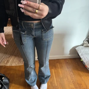 Blå jeans med låg midja - Snygga blå jeans med låg midja och raka ben. De har dekorativa sömmar och fickor fram. Perfekta för en avslappnad stil. Helt oanvänd byxor.
