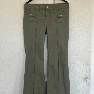 gröna jeans - Snygga olivgröna byxor med raka ben och dekorativa fickor framtill. 