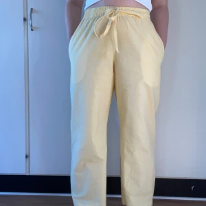 Gula linnebyxor med knytband - Snygga gula linnebyxor med elastisk midja och knytband. Perfekta för en avslappnad stil med en loose passform - egensydda, aldrig använda! De är lite genomskinliga men med ett par beigea underkläder i syns inget igenom😊 (Färgen liknar mest den på sista bilden)