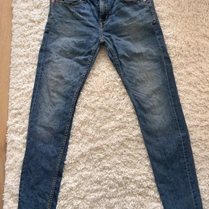 Blå jeans Stl M - Snygga blå jeans från Laget 157 i modellen Rocket. De har en klassisk design med fem fickor och en bekväm passform. Perfekta för en avslappnad stil.