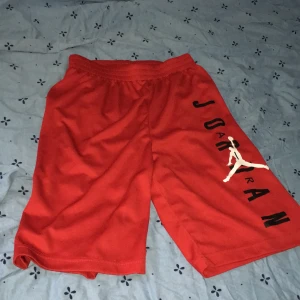 Röda basket shorts från Jordan - Tjena, säljer ett par snygga röda shorts från Jordan, väldigt sköna och använda ett fåtal gånger. Perfekta för sommaren och sportiga aktiviteter. Tveka inte att skriva om några funderingar.