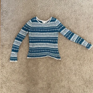 Mönstrad tröja från H&M - Säljer en snygg mönstrad tröja från H&M i blått och vitt. Tröjan har långa ärmar och ett fint mönster som passar perfekt för kyligare dagar. Den är i storlek XS och kommer från deras L.O.G.G. kollektion.