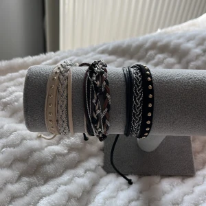 Flätade armband i olika färger - Säljer ett set med flätade armband i olika färger. Armbanden har detaljer som små pärlor och knytning. 