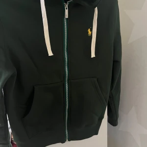 Grön hoodie från Polo Ralph Lauren - Säljer en snygg grön hoodie från Polo Ralph Lauren jag har använt den knappt den har inga skador eller liknande skrev för mer information 