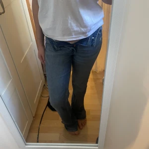 Bootcut jeans - Snygga blå jeans med bootcut-stil och medelhög midja. Perfekta för en avslappnad look. Klassisk femficksdesign och knäppning fram.