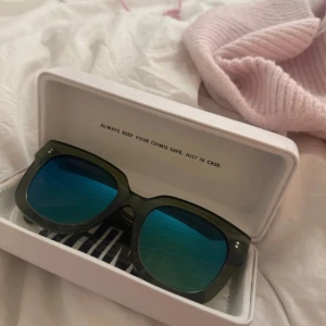 Gröna solglasögon från Chimi - Snygga gröna solglasögon från Chimi med blåtonade linser. De har en modern och stilren design med breda bågar. Perfekta för att ge din outfit en cool touch.