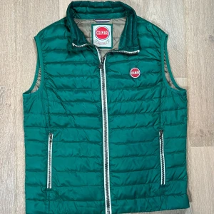 Grön quiltad dunväst från Colmar - Snygg grön quiltad dunväst från Colmar med dragkedja framtill och två praktiska fickor med dragkedjor. Alla plagg vi säljer är 100% äkthets varifierade💯🙌 snygg nypris 2799kr vårt pris 999kr dunder pris storlek M (50)