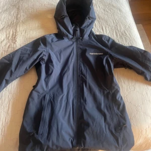 Marinblå jacka från Peak Performance - Säljer denna marinblåa jacka från Peak Performance med huva och dragkedja. Perfekt för kyligare väder eller skidåkning. Kommer inte till användning längre och är i mycket bra skick!