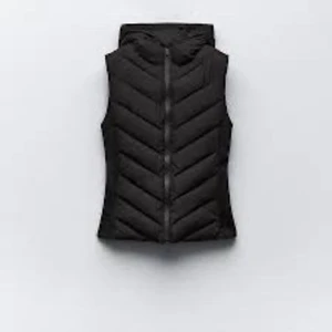 Svart dunväst med dragkedja - Snygg svart dunväst med dragkedja framtill. Perfekt för kyligare dagar och ger en stilren look. Västen har en quiltad design som ger extra värme och komfort. från zara knappast använd