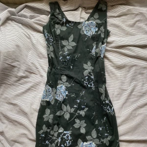blommig klänning - En vacker blommig klänning köpt på Myrorna. Sitter tight och elegant och passar perfekt både till vardags och till festliga tillfällen. Den slutar vid mitten av låren på mig som är 166 cm. Slitsen sitter bak på klänningen och slutar lite väl högt upp för min smak, men jag har ändå använt den mycket!