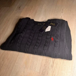 Mörkblå stickad tröja från Polo Ralph Lauren - Säljer en oanvänd och stilren stickad tröja från Polo Ralph Lauren färgad mörkblå. Tröjan är i storlek M och är köpt för cirka 1800kr. Säljer då den inte passar.