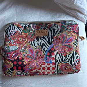 Unikt datorfodral - Säljer en färgglad datorväska med ett unikt mönster i zebrarandigt och blommigt. Väskan har en dragkedja och är perfekt för att skydda din laptop. Den har en mjuk insida för extra skydd.