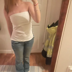 Vit tubtopp - Säljer en stilren vit tubtopp med slits på sidan, toppen är från Gina tricot för några år sen men sparsamt använd då den inte passar mig.