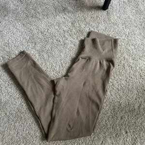 Beige ribbade leggings från Aim'n - Snygga beige leggings från Aim'n med ribbad struktur. De är högmidjade och har en tight passform som är perfekt för träning. Materialet är mjukt och stretchigt vilket ger en bekväm känsla under hela dagen.