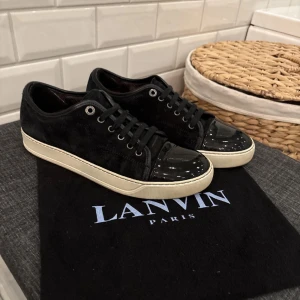 Lanvin uk6 - Snygga svarta sneakers från Lanvin med en stilren design. Skorna har en blank tå och snörning framtill. De kommer med en vit sula och levereras med dustbags. Bara att höra av sig till oss vid minsta fundering😁priset ej hugget i sten
