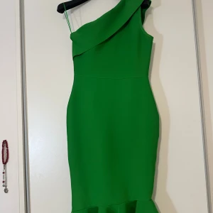 Grön oneshoulder klänning - Snygg grön oneshoulder klänning med dragkedja i sidan. Perfekt för en festlig kväll med sin eleganta design och figurnära passform. Funkar för M- L 