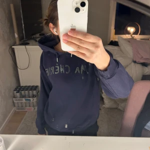 Mörkblå hoodie från Gina Tricot - Säljer en snygg mörkblå hoodie från Gina Tricot med texten 'MA CHÉRIE' i glittriga stenar på framsidan. Hoodien har en huva och ribbade muddar vid ärmslut och nederkant. Perfekt för en avslappnad stil! 💙passar perfekt på mig som brukar ha xs/s. Om ni har några frågor är det bara att skriva💕