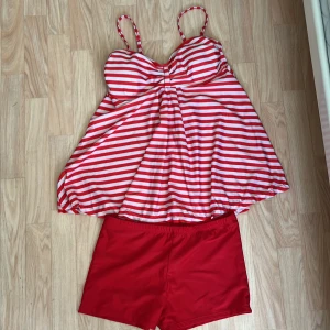 Rödvit randig linne-badtopp med badshorts - Säljer en söt linne-badtopp. Toppen har en lätt utsvängd form och vadderade kupor för extra stöd. Perfekt för strand eller poolhäng, matchas med röda badshorts. Materialet är mjukt och snabbtorkande. Aldrig använt, Storlek XL ❤️
