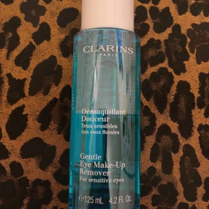 Clarins Eye Make-Up Remover 125ml - Clarins Gentle Eye Make-Up Remover för känsliga ögon, 125 ml. Blå, genomskinlig vätska i plastflaska med vit kork. Innehåller blomvatten och är parfymfri. Perfekt för att ta bort smink runt ögonen utan att irritera huden.