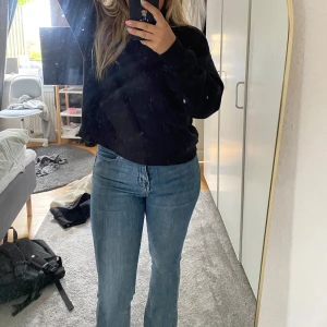 Blå bootcut jeans med hög midja - Säljer ett par klassiska blå jeans med bootcut och hög midja. Jeansen har en snygg, något ljusare tvätt och raka ben som går ut lite nertill. De är i stretchigt jeanstyg och har fem fickor samt dragkedja och knapp framtill.