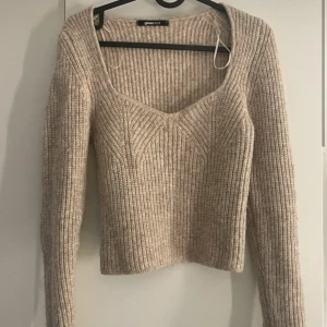 Beige ribbstickad tröja Gina Tricot - Superfin beige ribbstickad tröja från Gina Tricot med djup v-ringning och lång ärm. Tröjan är croppad och har en snygg, figurnära passform som passar perfekt till höst- och vinteroutfits. Hör av er för mer bilder ❤️