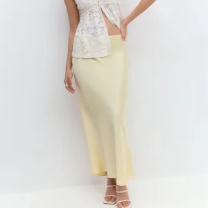 Gul satinkjol - Jättefin gul satinkjol ifrån Gina! Den har lite små trådar som sticker ut och mindre fläckar men inget som man tänker på mycket när man använder den! Fläckarna kanske går bort med fläckborttagning, jag har inte testat.