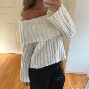 Vit offshoulder stickad tröja - Superfin vit stickad tröja med bred offshoulder-ringning och ribbat mönster. Tröjan har lång ärm och en lite loose passform. Nyskick.