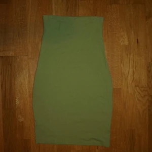 Olivgrön tight kortklänning - Säljer en olivgrön kort klänning med tight passform. Klänningen är enkel och stilren utan detaljer
