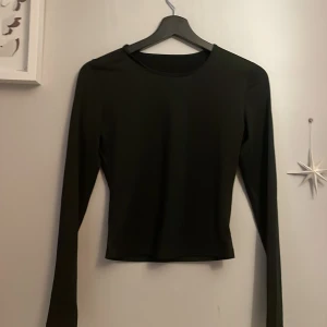 Tajt kort långärmad tröja - Kortare tröja som sitter tajt mot kroppen, materialet är som en träningströja! 