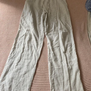 Randiga linnebyxor med snörning från Gina tricot - Snygga grå/vit randig linnebyxor med avslappnad passform. Lappen är avklippt men jag har storlek 158/164 i storlek så de är npn av de storlekarna, skulle mer tro på 164❤️ Byxorna har elastisk midja med snörning och raka, vida ben. Perfekta för varma dagar när du vill ha en chill och luftig stil. Använda max en gång❤️