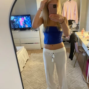 Vita mjukisbyxor/ linnebyxor med snörning - Säljer ett par vita mjukisbyxor/ linnebyxor Byxorna har en loose och relaxed passform med raka ben, perfekta för chill dagar. Materialet är mjukt och bekvämt, och midjan är hög för extra komfort.