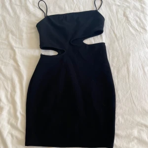 Svart cut out klänning  - Säljer en svart kort klänning med tight passform från Zara, klänningen har tunna axelband och cut out-detaljer i midjan. Klänningen passar både en xs och s pga att den är så stretchig. Den har aldrig kommit till användning men prislappen är avklippt.