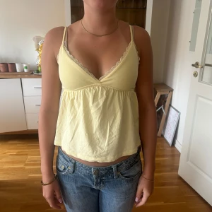 Ljusgul linnetopp med spetsdetalj - Supersöt ljusgul linnetopp med smala axelband från Subdued i storlek S men passar också som XS.