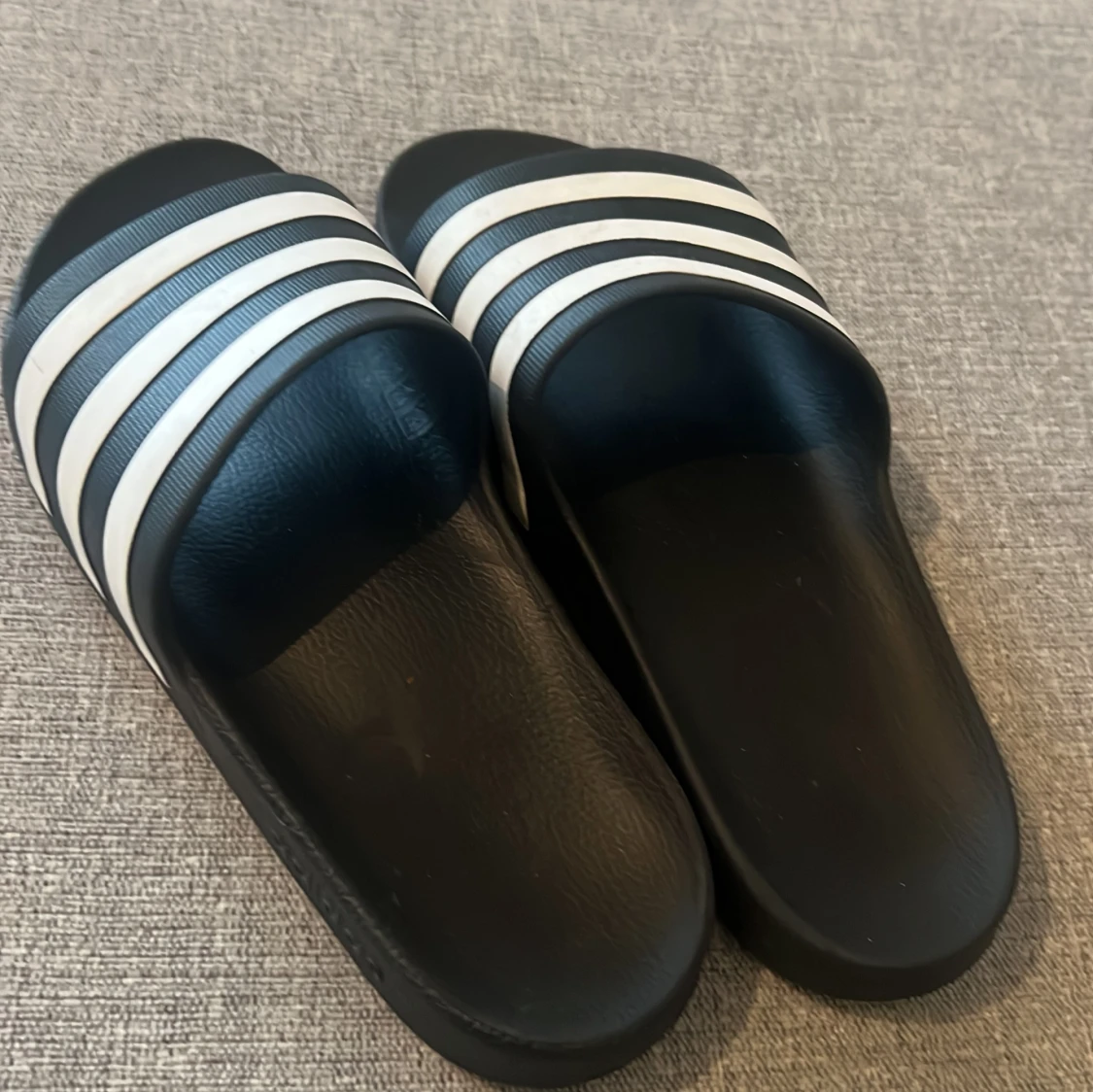 Svarta Adidas sandaler med vita ränder